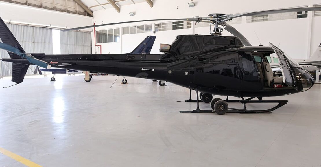 Helicóptero Esquilo AS350BA ano 1994 à Venda na Gualter Helicópteros com duas mil e setecentas horas totais de voo. Aeronave usada à venda no Brasil. O helicóptero se encontra pousada em um hangar coberto. Possui a pintura preta com interior bege claro.